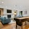 Community lounge at our apartments for rent in South Boston MA featuring 4 blue armchairs, fire place, tv, and a game area.